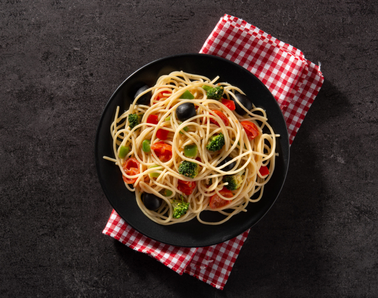 Spaghetti with vegetables(broccoli,tomatoes,peppers) on black background
